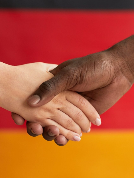 Close-up of people shaking hands against the German flag